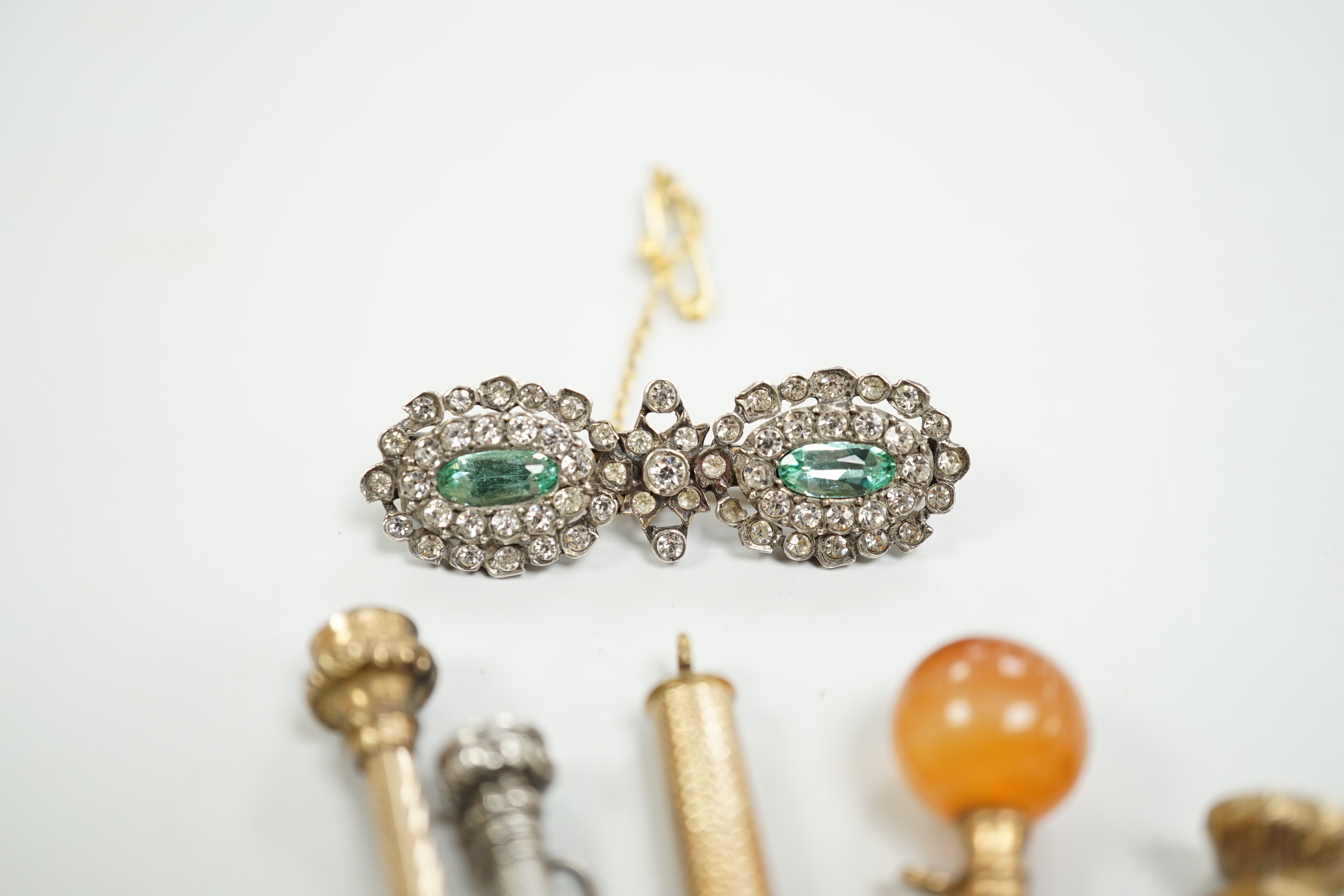 Four assorted early 20th century yellow or white metal overlaid propelling pencils, an agate set button hook, a two colour paste brooch and a Victorian enamelled mourning brooch, with plaited hair.
